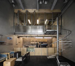 Industrial-style coffee shop with metal counter and industrial lighting