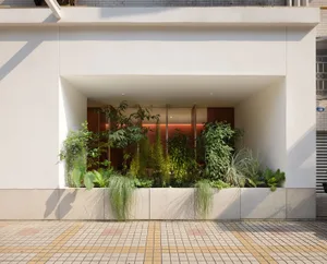 A retail store with a green roof, showcasing vertical gardens and sustainable design features.