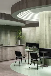 Modern cafe interior with pastel tiles and concrete design elements.