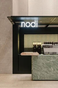 Minimalist design of a coffee shop counter with marble top and sleek, modern aesthetics.
