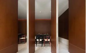 A minimalist restaurant interior with wooden walls and flooring.