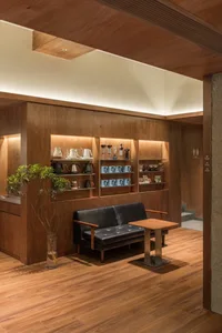 A modern coffee shop featuring wooden interiors and furniture.
