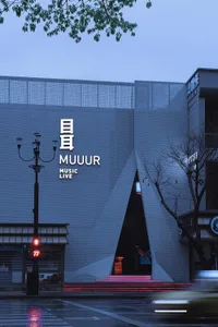 Modern, metallic-clad music live venue at dusk with illuminated steps.