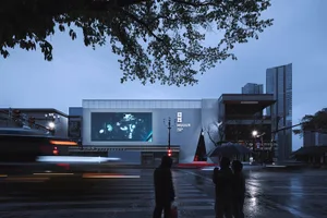Modern public space with large glass panels, steel framing, and LED lighting.