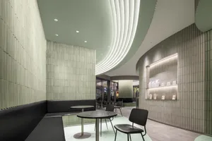 Contemporary restaurant interior with textured concrete walls and ceiling, modern furniture, and sophisticated lighting.