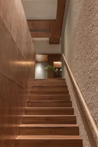 Modern staircase featuring wood paneling and a handrail.