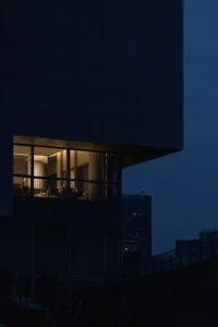 現代建築室內視角，窗戶在夜色中透出燈光。