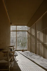 A modern restaurant interior with clear glass walls and wooden elements.