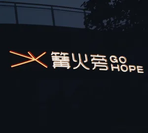 A minimalist neon sign with the words '火旁 GO HOPE' and an illuminated cross symbol.