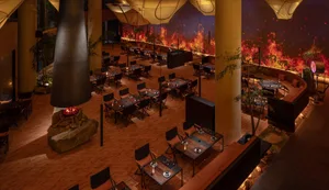 Modern dining hall with wooden floors, metal furniture, and glass elements.