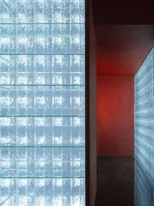 A modern interior space featuring a wall covered in textured glass panels.