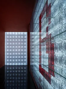 A modern interior design with a glass wall featuring red accents
