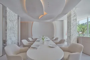 Modern restaurant interior with marble walls and white fabric chairs