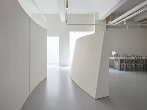Modern office space featuring white-cement walls and minimalist design.