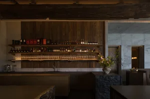 現代餐廳吧台，搭配木質層架、大理石與石材點綴，以及花卉擺飾。