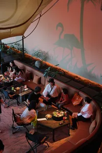 People dining in a modern restaurant interior with a carpeted floor and a tent structure