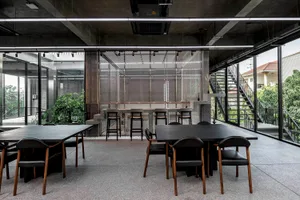 An industrial-style restaurant with metal, concrete, and glass elements.