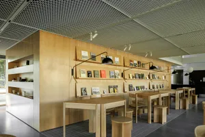 A modern library interior featuring wooden panels and built-in shelves filled with books.