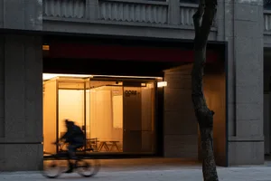 A modern cafe storefront with glass walls and timber elements.