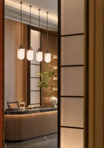 A modern tea room with wooden accents, marble table, and glass pendant lights.