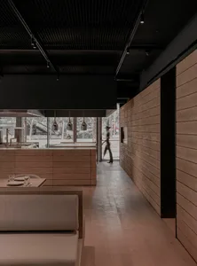 Industrial-style restaurant interior featuring wooden walls and concrete surfaces.