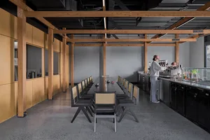 現代工業風格辦公室，配有長木餐桌，咖啡廳氛圍含吧台與咖啡機，混凝土地面