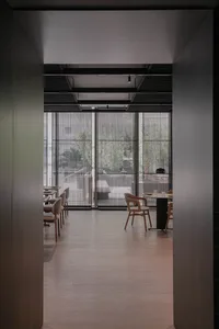 Modern restaurant interior with wooden seating, metal railings, and glass partitions