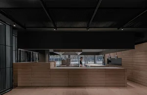 Modern bar counter with wooden panels and overhead lighting in a contemporary space.