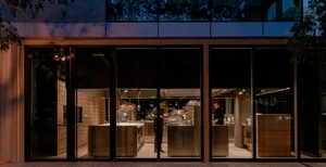 A modern cooking area with stainless steel appliances and white countertops.