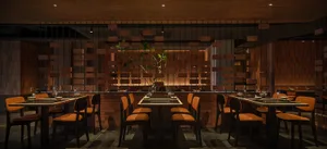 現代餐廳室內空間，採用磚牆與木質元素，搭配俐落餐桌椅。