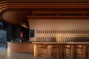 A modern bar interior with porcelain walls and metal bar