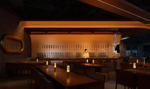 A modern bar interior with industrial design elements and warm lighting.