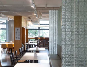 Modern cafeteria interior with glass walls and wooden furniture.