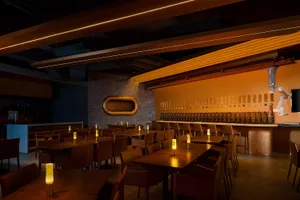 A modern restaurant bar with warm lighting and Walnut wood finish