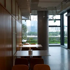 A modern restaurant cafe interior featuring concrete and wooden elements.