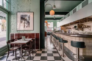 Modern cafe interior with a tiled counter featuring black and white tiles.