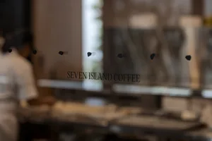 A modern coffee shop interior view through a glass window.