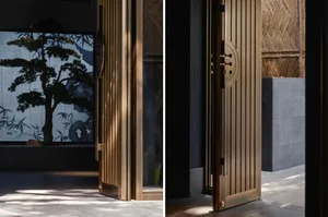 A modern entrance with bronze doors featuring geometric designs against a dark interior background, creating a sleek and eleg