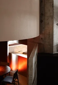 A modern industrial restaurant interior featuring concrete and wood materials.