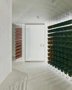 A minimalist interior design featuring concrete walls and metal shelving units.