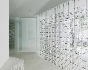 A modern minimalist room interior with a unique metal frame wall design.