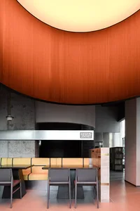 Modern interior design of a restaurant dining room featuring wooden elements and curved architecture.