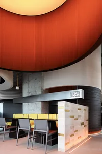 Modern restaurant interior with concrete walls and bar seating