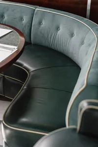 A green leather booth seat in a restaurant setting.