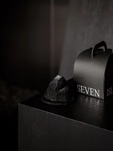 Black minimalist product packaging with 'SEVEN ISLANDS' text on a black surface.