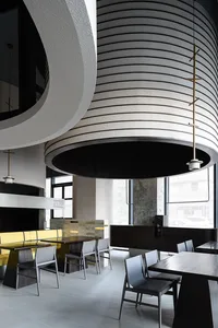 A modern cafe interior with concrete walls and wooden furniture.
