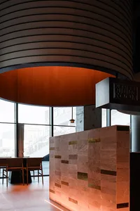 An image of a modern minimalist restaurant interior featuring concrete and brick materials.