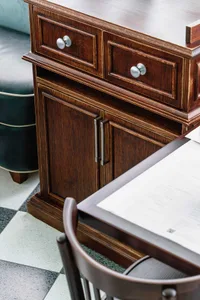 Close-up of a modern office desk made of wood with a drawer and cabinet.