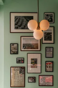 A wall adorned with framed photographs in a restaurant interior.
