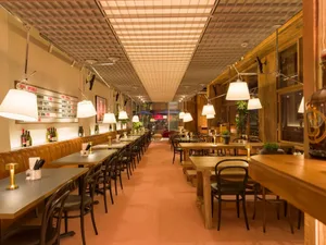 Modern industrial-style cafe interior with wooden tables and chairs.
